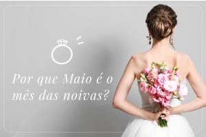 Fundo cinza, à direita uma noiva de costas segurando um buquê de flores cor de rosa, à esquerda um desenho de um anel de noivado e escrito em branco: Por que maio é o mês das noivas?