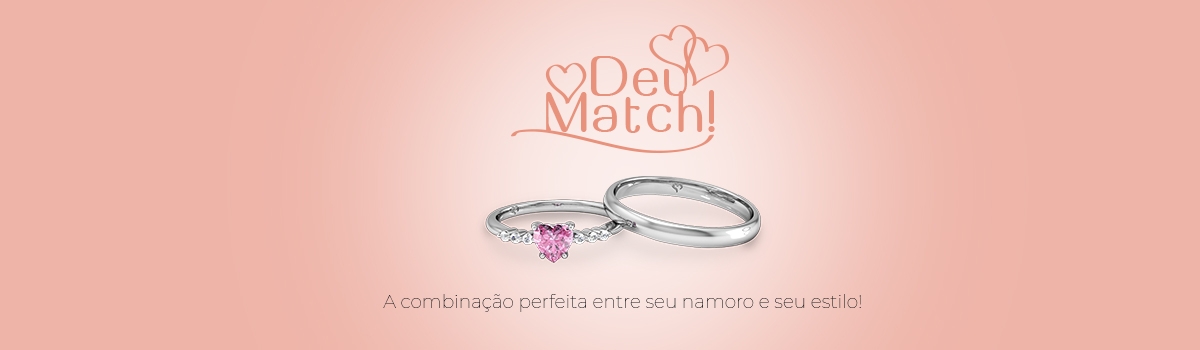 Aliança de namoro clássica perto de um anel de prata com pedra rosa de coração e algumas pedras brancas laterais.