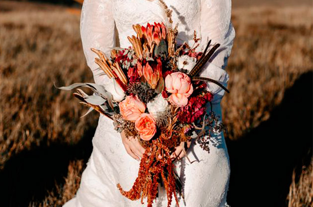 Estilo assimétrico Buquê de noiva assimétrico, com flores e folhas em tons de laranja e terrosos