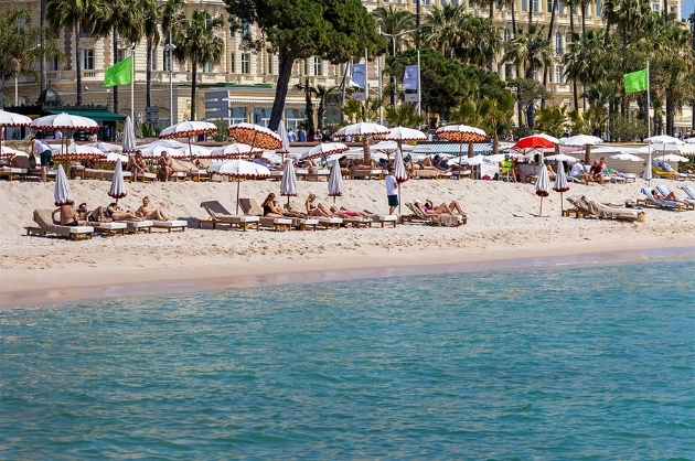 Cadeiras de praia à beira mar próximo a um hotel de luxo