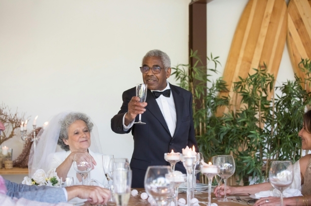 Casal de idosos noivos brindando em uma cerimônia de casamento