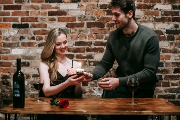 Casal sorrindo durante um jantar romântico