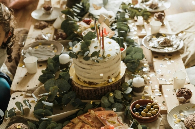 Mesa de comida para casamento rústico com petiscos e guloseimas, bolo em estilo rústico com glaçagem imperfeita e enfeite de folhas