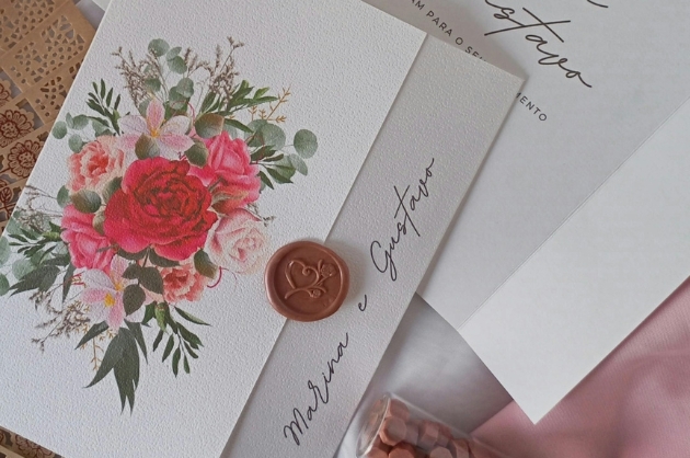 Convite de casamento em papel branco e flores rosas e vermelhas com folhagem verde