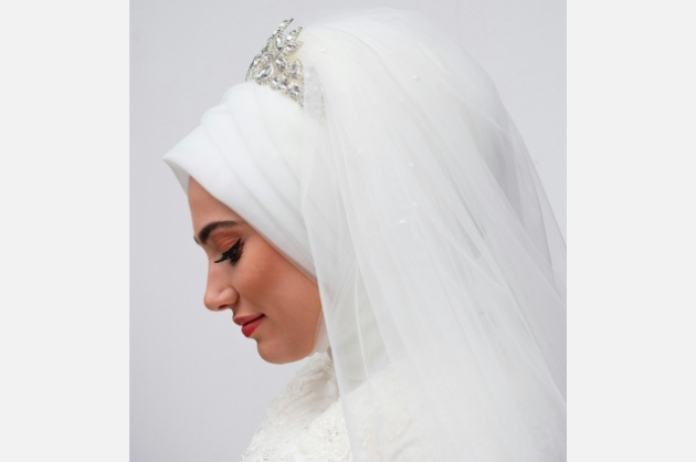 Noiva muçulmana com véu e hijab brancos de perfil sorrinfo