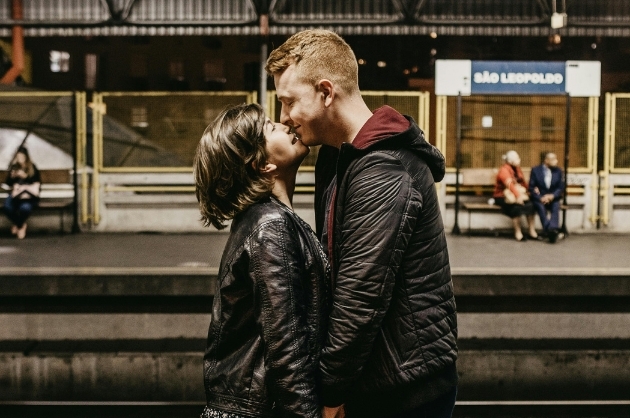 Casal se beija em uma estação de trem